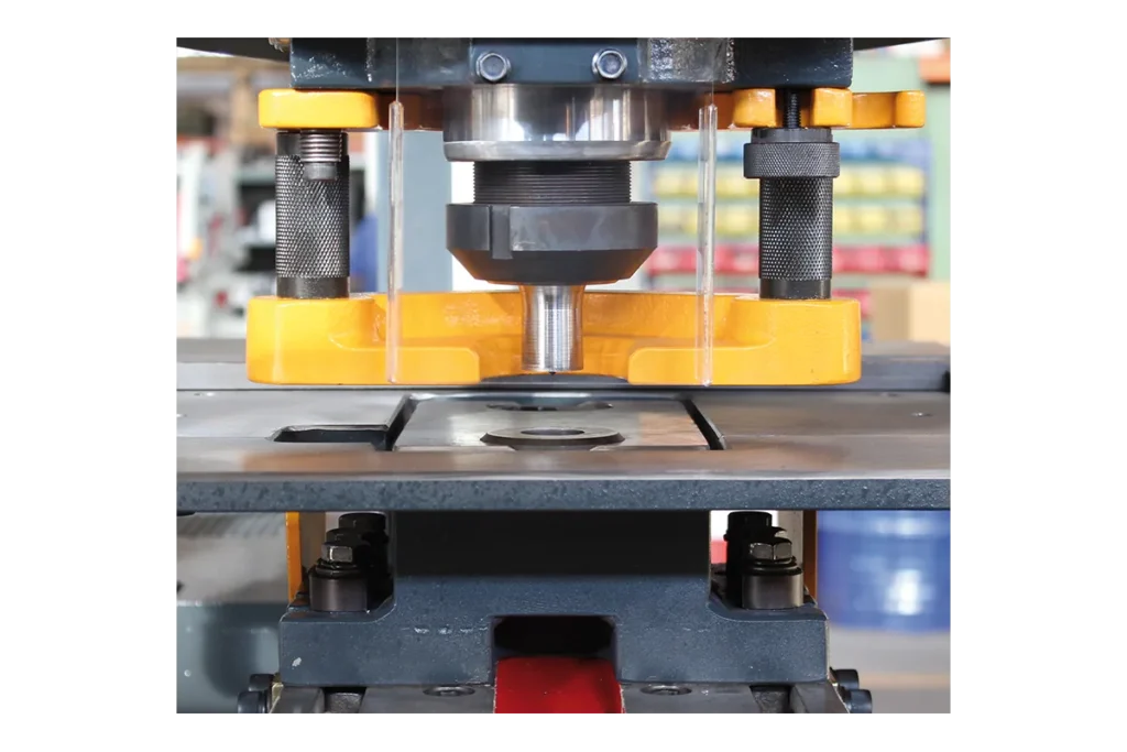 Punching station of an HSW hydraulic ironworker with punch, die and stripper.